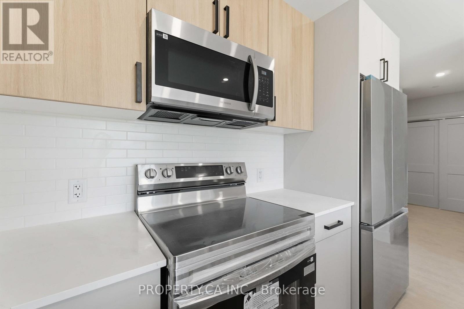 Kitchen with stainless steel range and microwave at Parkside Living Thorold